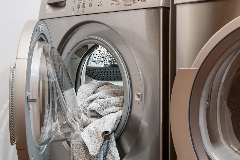 Washing machine with laundry being loaded inside