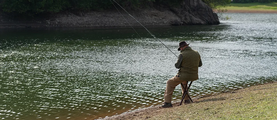 Man sat at the end of the reservoir fishing