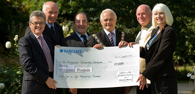 Colin Skellett holding a cheque for St Margaret's Somerset Hospice
