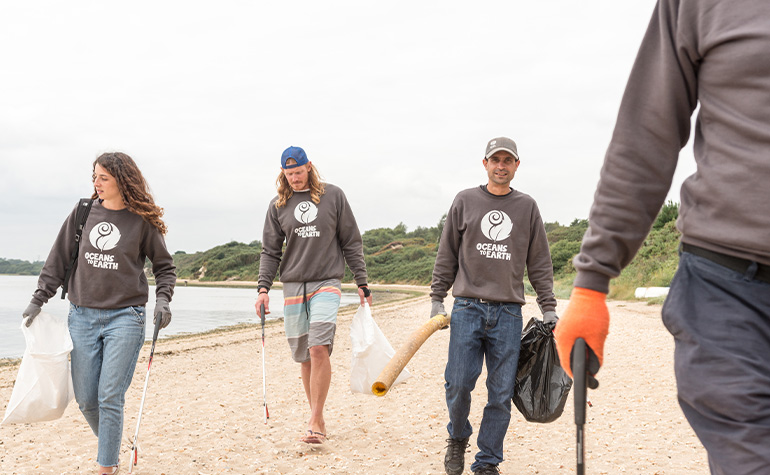 Oceans To Earth Volunteers cleaning a beach