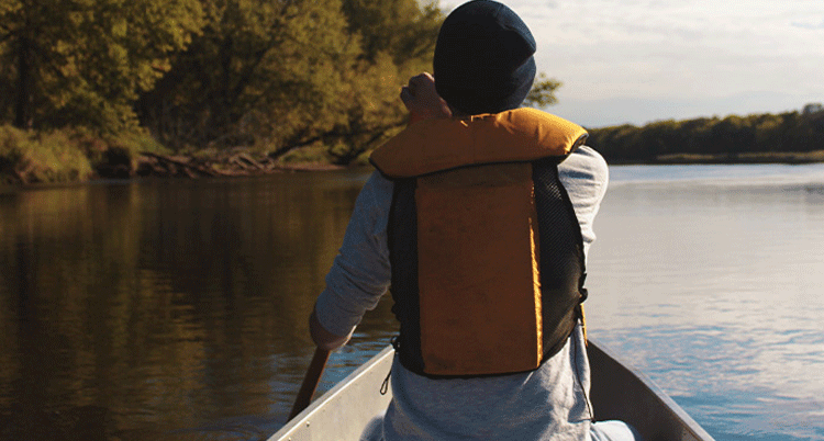 Man sat in a canoe on a lake